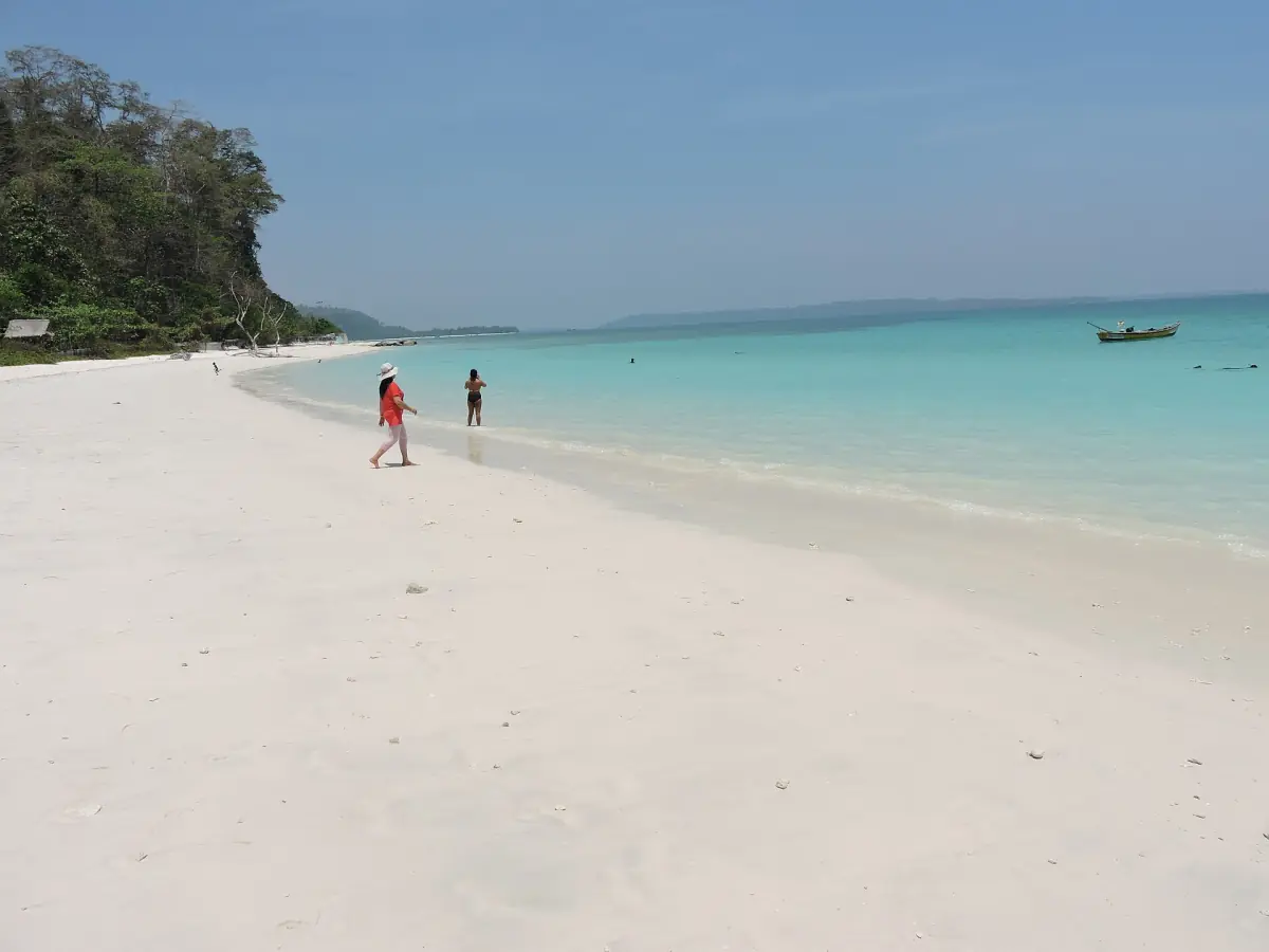 Long white shore of Kalapathar Beach with forested headland