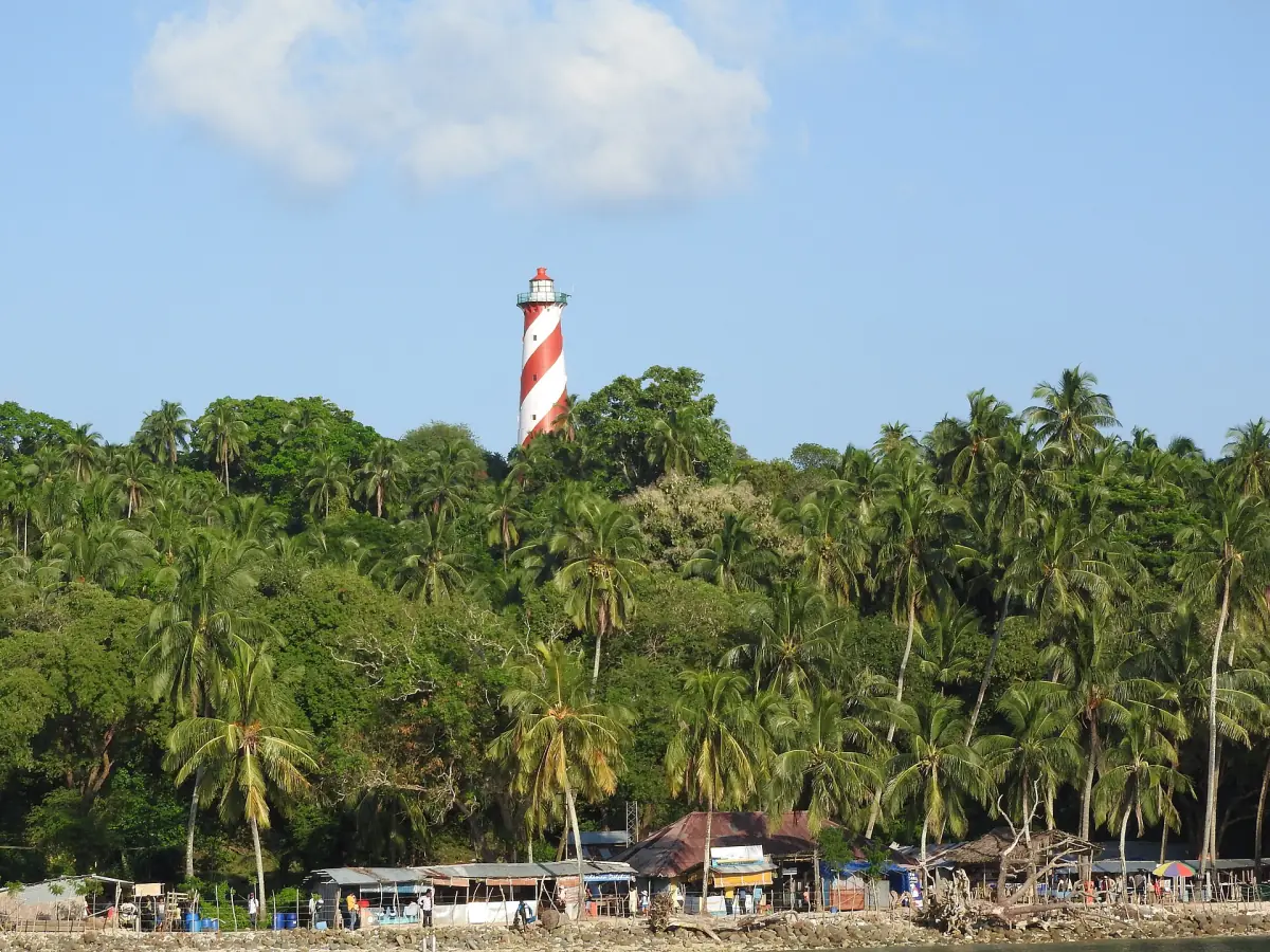 North Bay Island lighthouse above the palm forest and beach huts