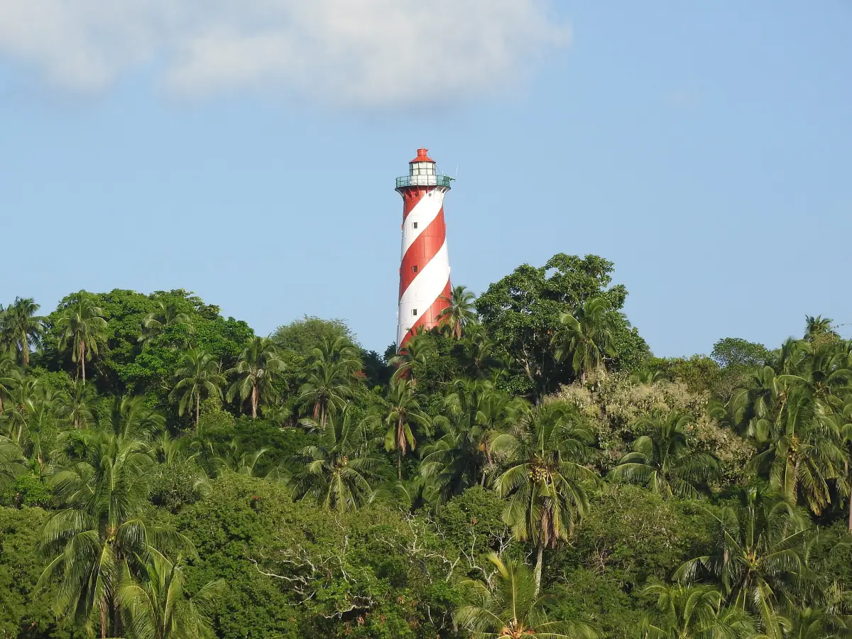 Red and white striped lighthouse rising above trees on North Bay Island